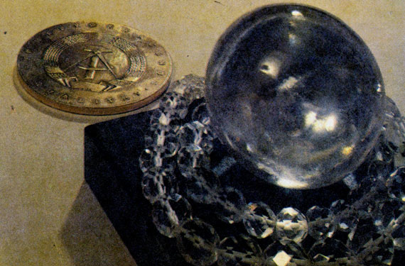 Фото IX. Хрустальный шар, обвитый хрустальным ожерельем. Несмотря на незначительную дисперсию света в кварце, камень кое-где 'играет'. Минералогический музей ВНИИСИМСа