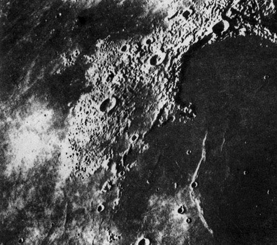 Видимая сторона Луны - Залив Радуги Океана Бурь. Отчетливо видно, как молодые лавовые потоки базальтов перекрывают древние кратерированные материковые поверхности