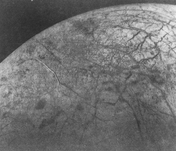 Спутник Юпитера - Европа. Отчетливо видна сеть гигантских трещин, заполненных темным материалом